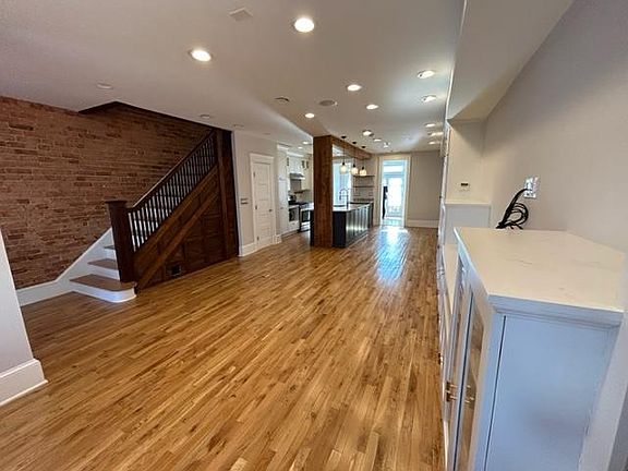 Large living space with built-in cabinetry, bookcases, and under stairs storage.