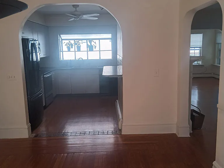view of kitchen and living room from dining room. open plan with arches
