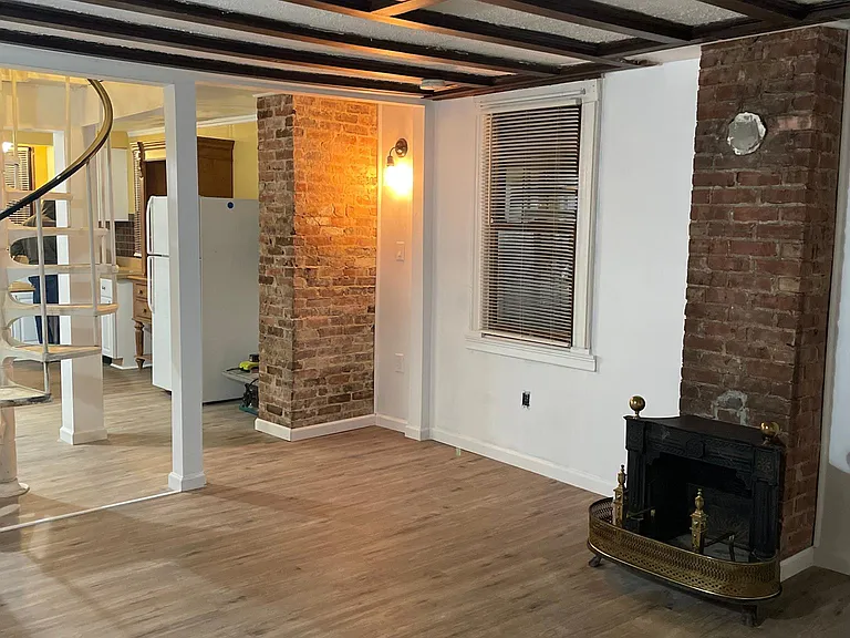 Open living room and kitchen plan with vintage spiral staircase to bedrooms upstairs.