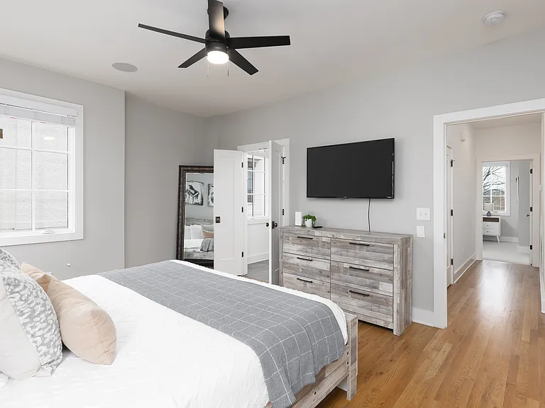 Primary bedroom on the 2nd floor with a king bed, Smart TV, ensuite bath, and room darkening shades. Includes a large walk-in closet. Tastefully decorated with high-end modern furnishings.