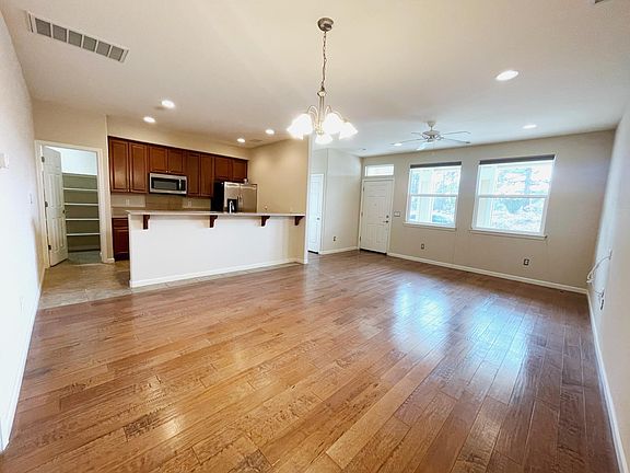 Living room w/ hardwood flooring, kitchen breakfast bar