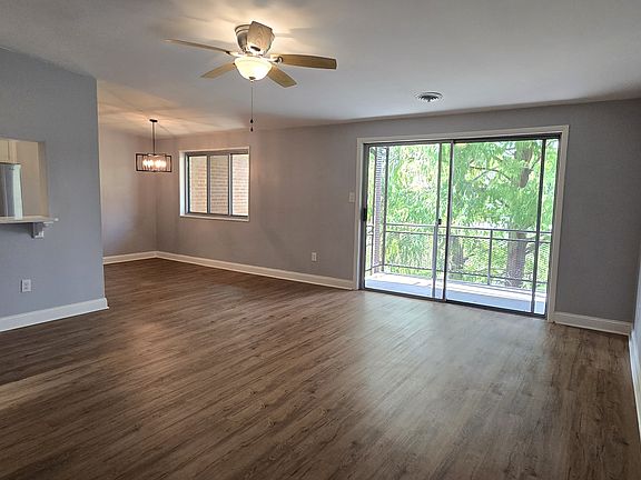 Spacious living area with connecting balcony and 10 foot vaulted ceilings throughout the home