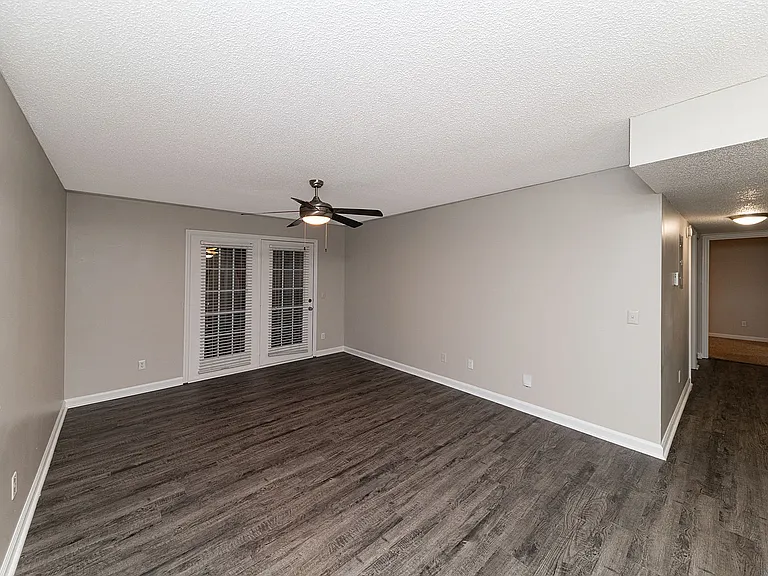 Spacious living room with hardwood-style flooring & overhead lighting
