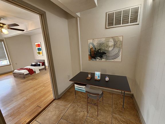 Virtually staged picture of desk nook and secondary bedroom.