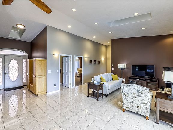 Standing in the entry looking towards the living room. Vaulted ceilings with ceiling fans. Bathroom is first door on the left then the 2nd bedroom.>