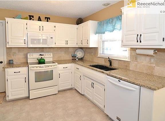 Life happens here! Enjoy bright, light and everything you need to create meals plus granite counters, under-cabinet lighting, tile floor and backsplash