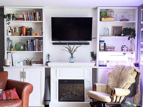 Built-in shelving leaves room for your TV, books, plants, and games, and an electric fireplace keeps things cozy.