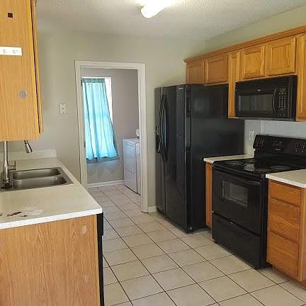 Kitchen with appliances, tile floor