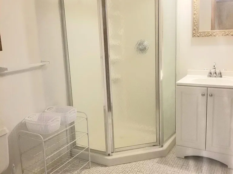 There is a full bathroom attached to the second bedroom, which is downstairs - ceramic floor, white vanity, Moen fixture, golden mirror, new light fixture, white satin walls, stand in shower, etc.