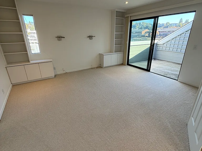 Primary bedroom with deck access and water views.