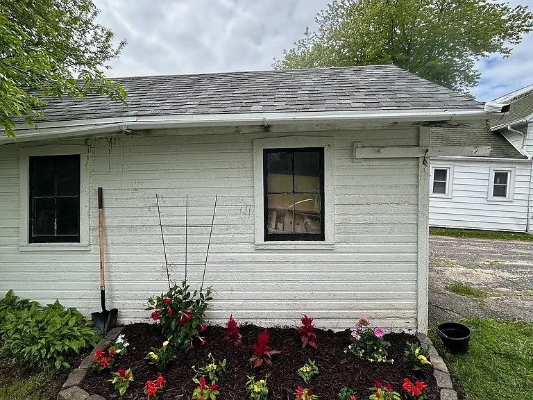 Raised, bordered garden bed in the back yard. Detached, single car garage pictured in back.