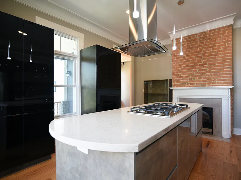 Two modern China, cabinets with light and smoked glass doors. Suspended book/display case next to exposed brick gas fireplace.