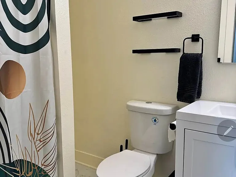 Bathroom with shower stall. There is a small cubby space on the side of the shower stall for more storage.