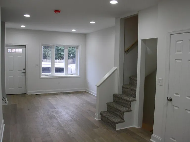 View from dining area to lounge, trinity staircase, full basement entryway and 1/2 bath.