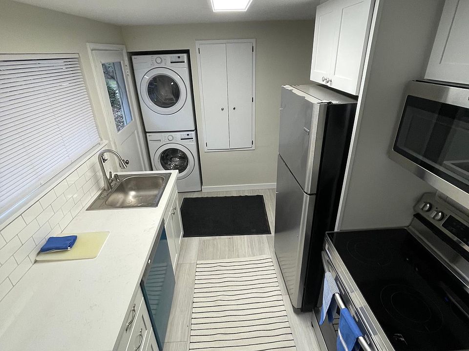 Renovated kitchen with all new stainless steel appliances featuring stacked washer/dryer in unit.