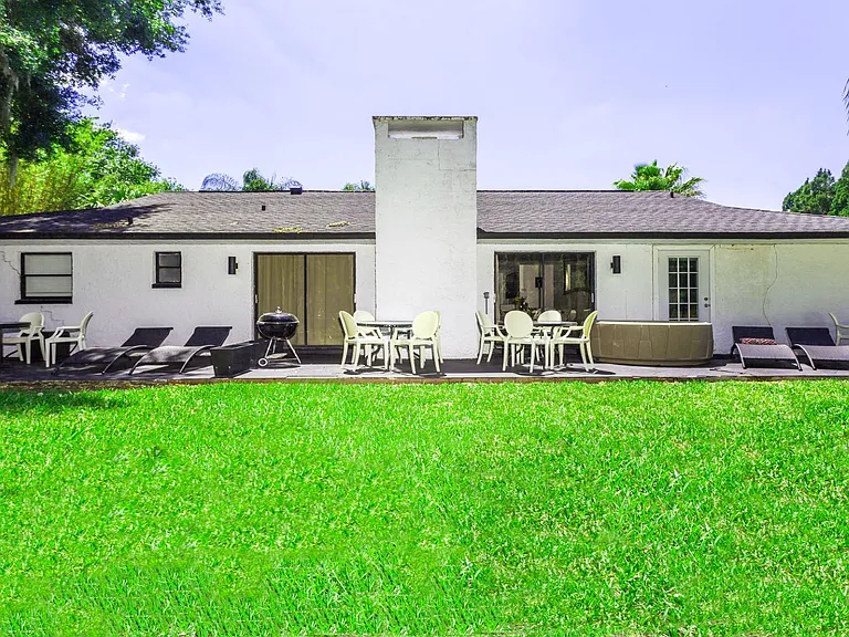 Back garden with outdoor living room style patio area overlooking lake and Saddlebrook Golf Resort Course.