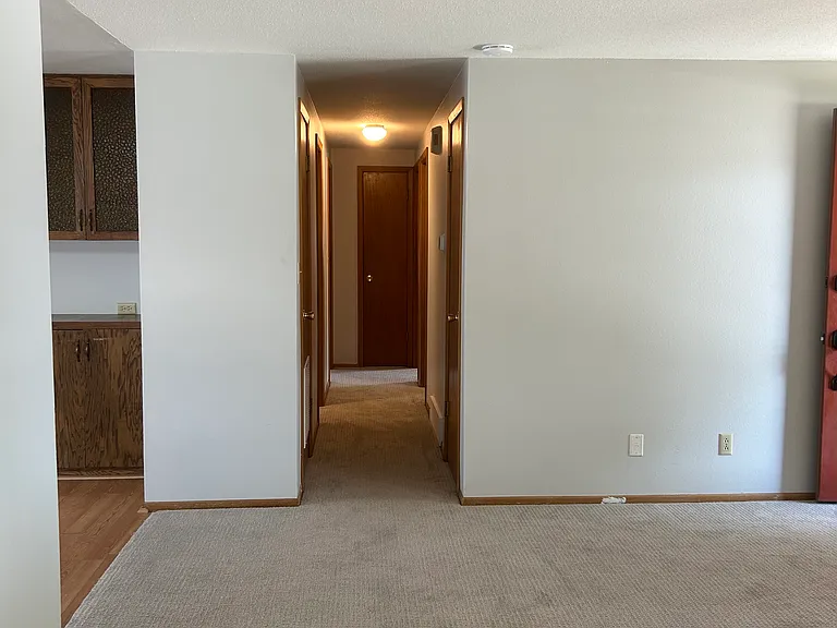 In the living room looking down the hall at the 3 bedrooms and full bathroom