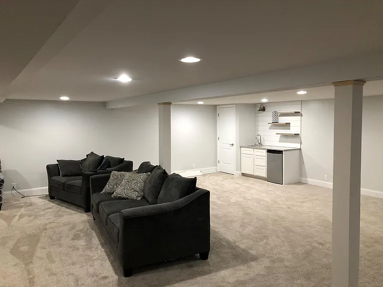 Large, carpeted basement family room; small wet bar