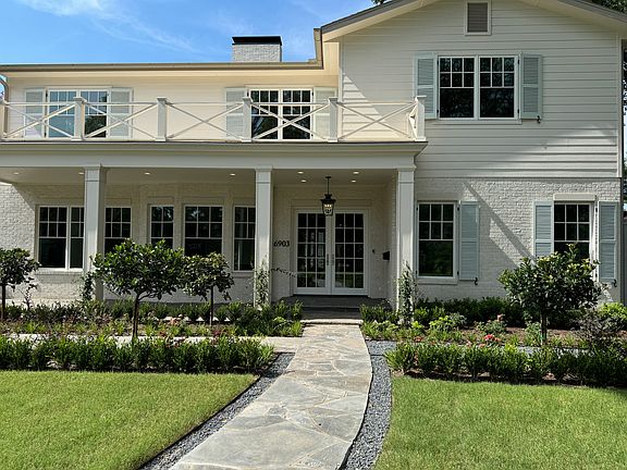 Bungalow vibe with new shutters and beautiful fretwork on balcony.