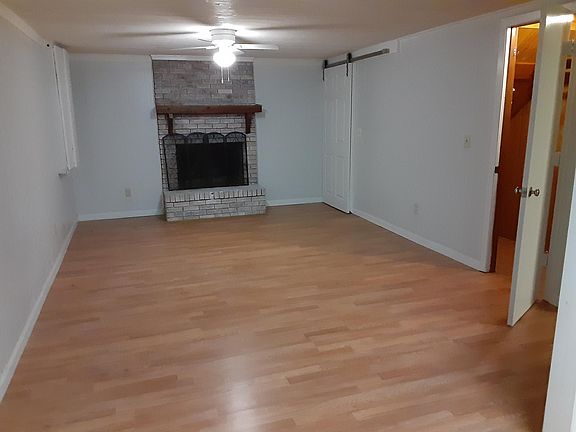 Main room , closet with opened door, barn door leads to landlord upstairs. Fireplace only decorative . New laminate flooring