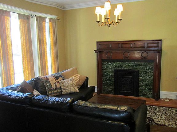 Crown molding, decorative mantel with tile surround, wood floor.