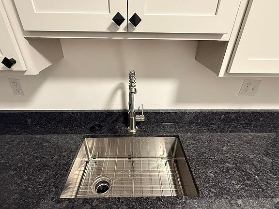 Large basin sink with modern faucet and granite countertops