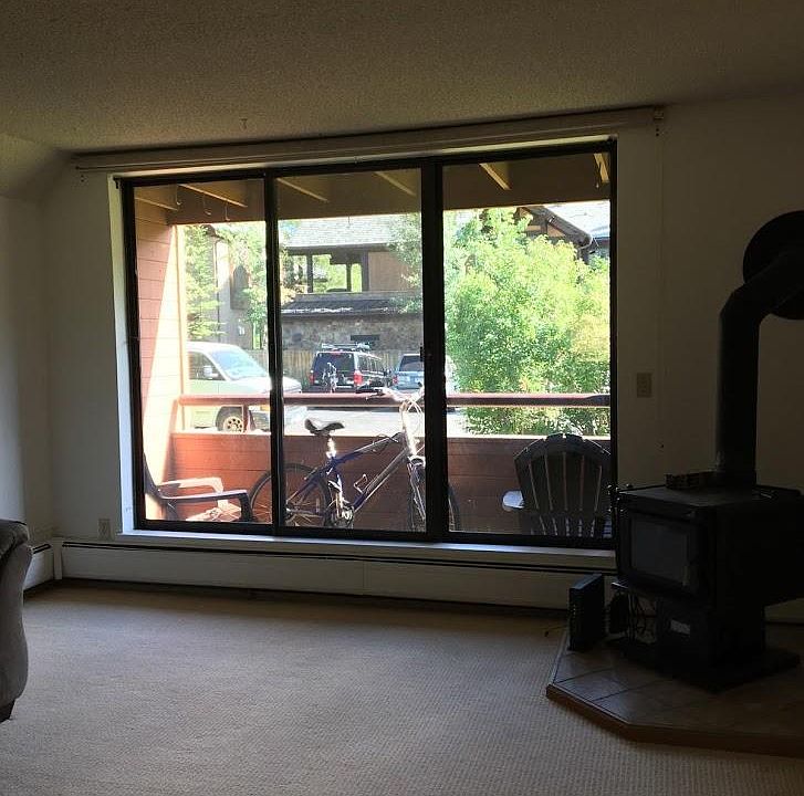 Living room with wood stove, looking out onto deck