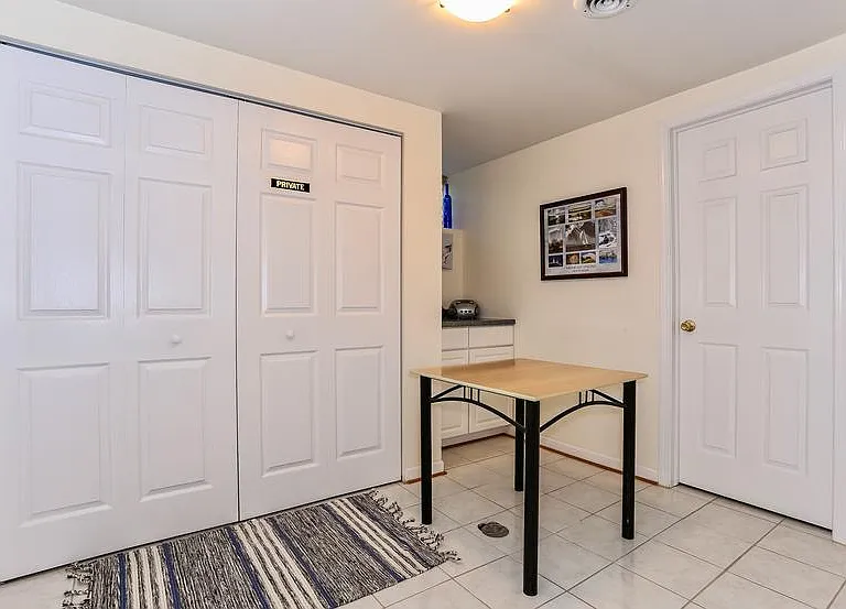 The laundry. A newer washer and dryer stands behind the folding doors plus a folding table in front for your convenience.