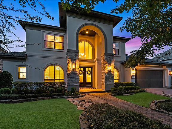 Newly painted exterior, paver walkway and wooden garage doors add to the beauty of this home.
