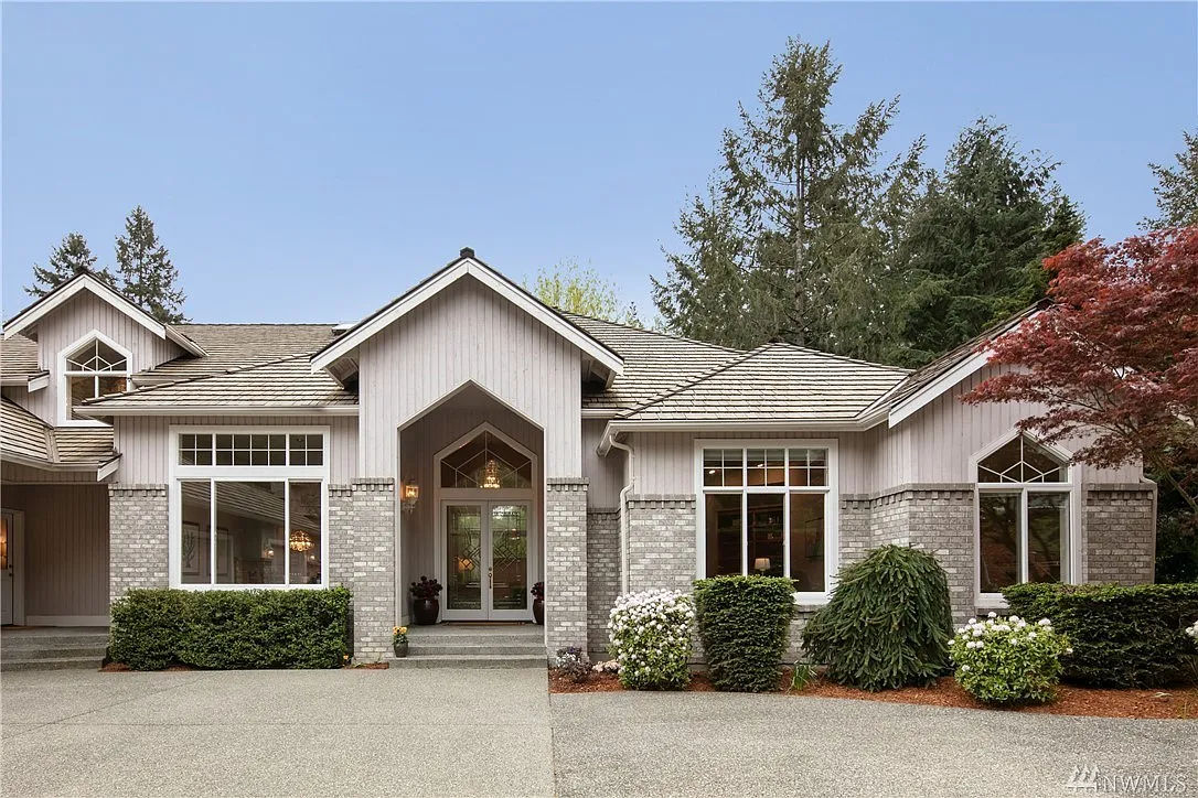 Stunning curb appeal with a grand arched entry, brick accents, soaring windows, and manicured landscaping _ including a striking Japanese maple. This home makes an unforgettable first impression. - 23949 NE 69th Pl
