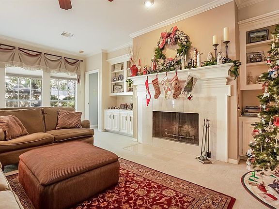 Den has Wall of Windows for Lots of Natural Light, Wood Burning Fireplace with Gas Starter and Marble Tile Surround and Wood Mantel.