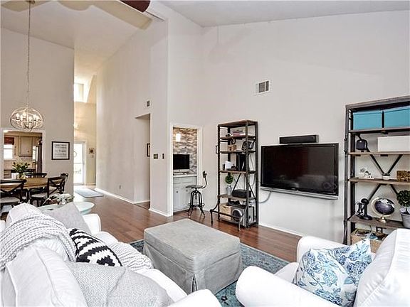 Enjoy a spacious living / dining area with vaulted ceilings and view of beautifully landscaped, private and shady patio area.  Computer nook is interesting update of old wet bar!