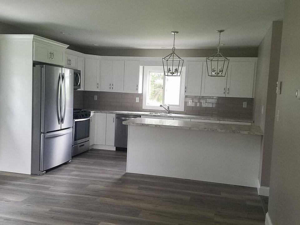 Large kitchen with peninsula and new cabinets and appliances , tile back-splash