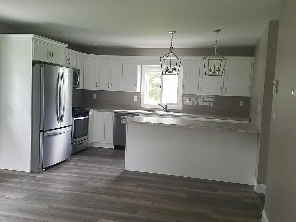 Large kitchen with peninsula and new cabinets and appliances , tile back-splash