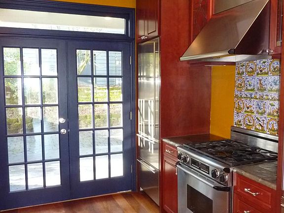 Beautiful kitchen features gas range and separate sub zero freezer and refrigerator.