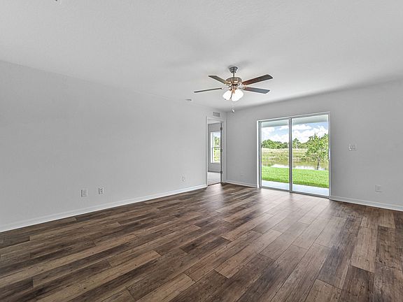 The Amelia s living room with a sliding glass door that leads the the back patio and backyard