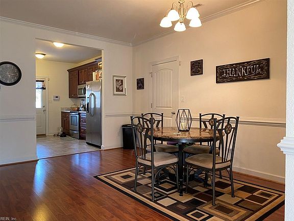 Dining area with chandelier, chair rail and crown moulding.