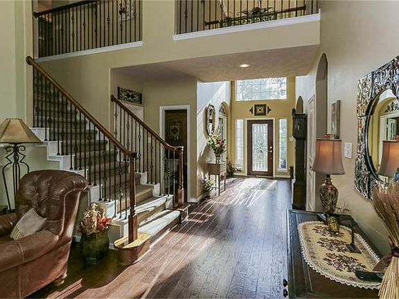 Two story entry and family room with recently installed hardwood floors with corner fireplace