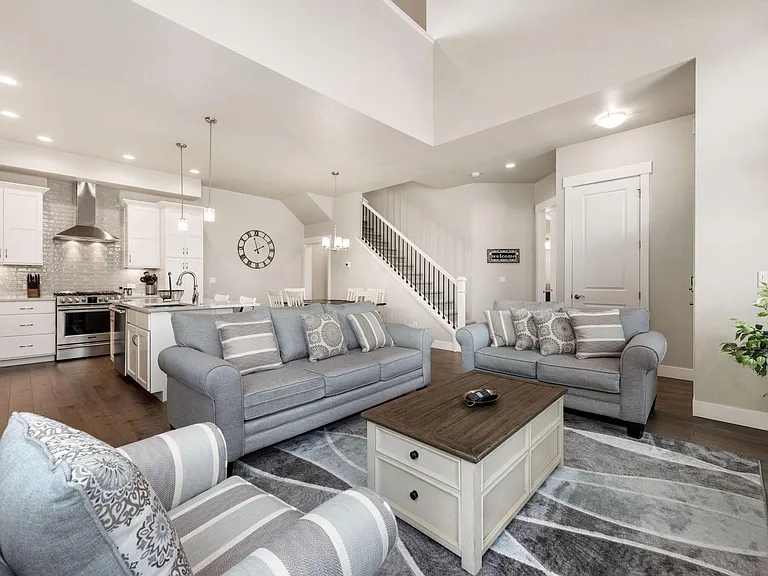 View of living room with kitchen, dining room and stairs to the upper level