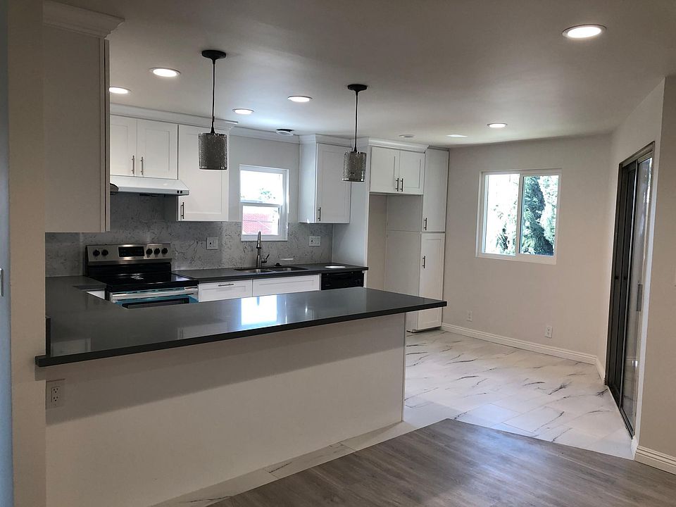 OPEN KITCHEN SPACE WITH BRAND NEW FLOOR, LIGHTING,, AND AMENITIES. DIRECT ACCESS TO THE LIVING ROOM AND PRIVATE PATIO.