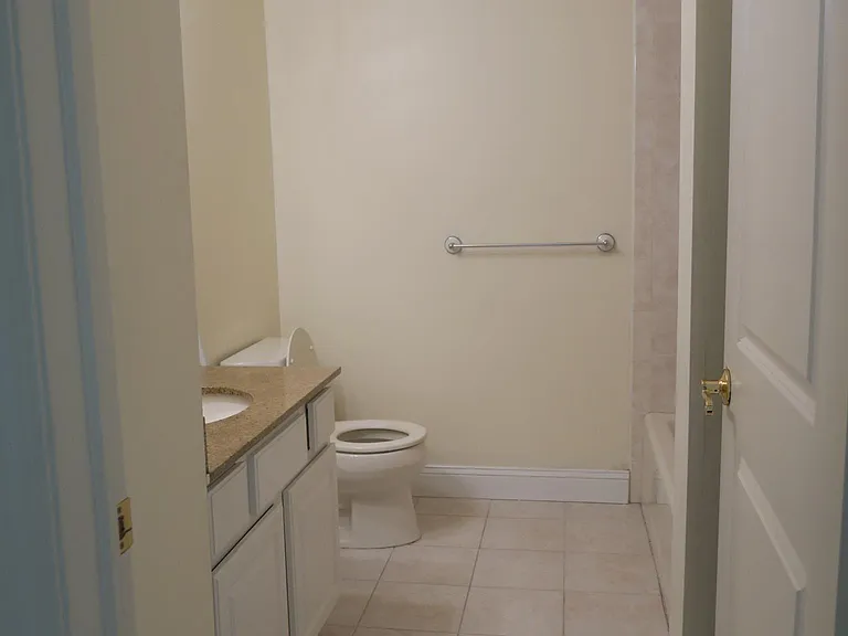View into the bathroom, which has granite countertop.