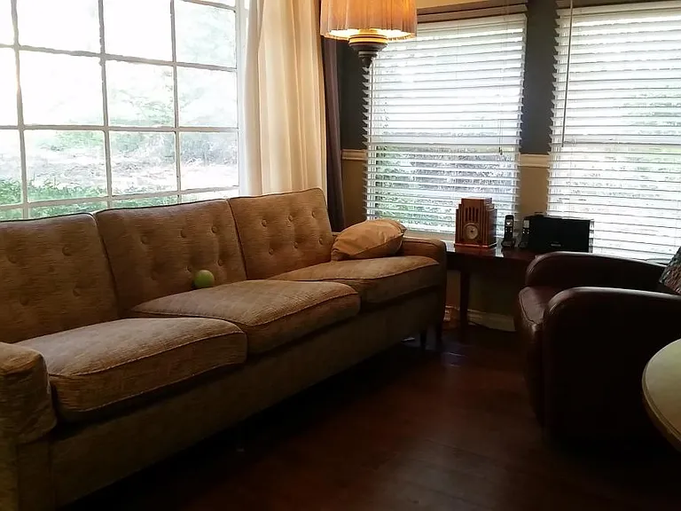 Old photo of back living area (Rm #2) over looking the pool how a previous tenant used the room. The large window has been replaced and flooring is new. *Apt is unfurnished.