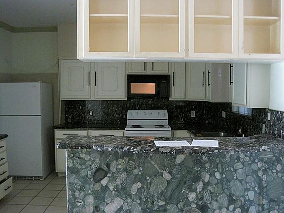 Kitchen with custom cabinets and countertops/backsplash