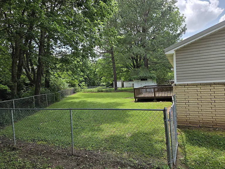 Fenced backyard with deck