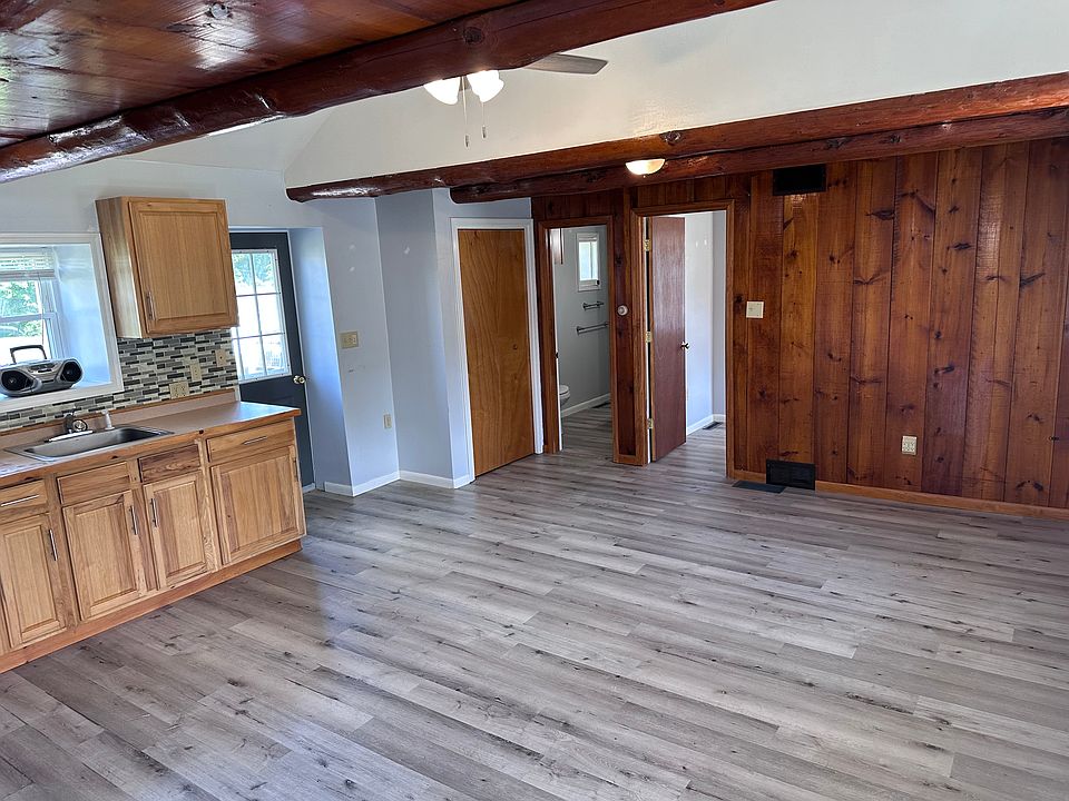 Kitchen area looking into living area towards smaller bedroom and bathroom.