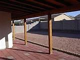 back covered patio in pool sized yard
