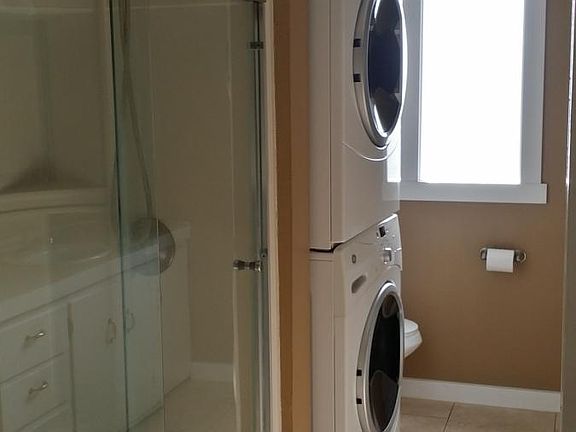 Bathroom w/ frontloaders, travertine tile