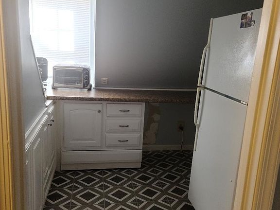 Kitchenette with refrigerator, and cabinets. Microwave, Toaster Oven, and Nuwave Cook Top All Provided for use. No Oven.