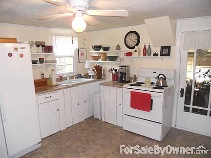 Kitchen but not a recent photo : The kitchen now has wall cabinets instead of shelving. Curtains on 
