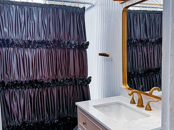 Stunning new bathroom renovated with clawfoot tub and gilt faucets and crystal and gilt lighting.